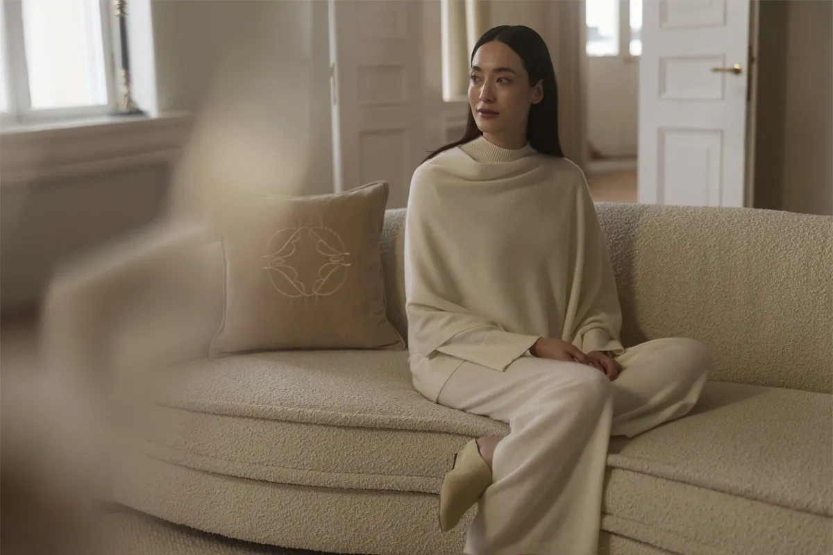 Soft beige image displaying a woman sitting on a couch